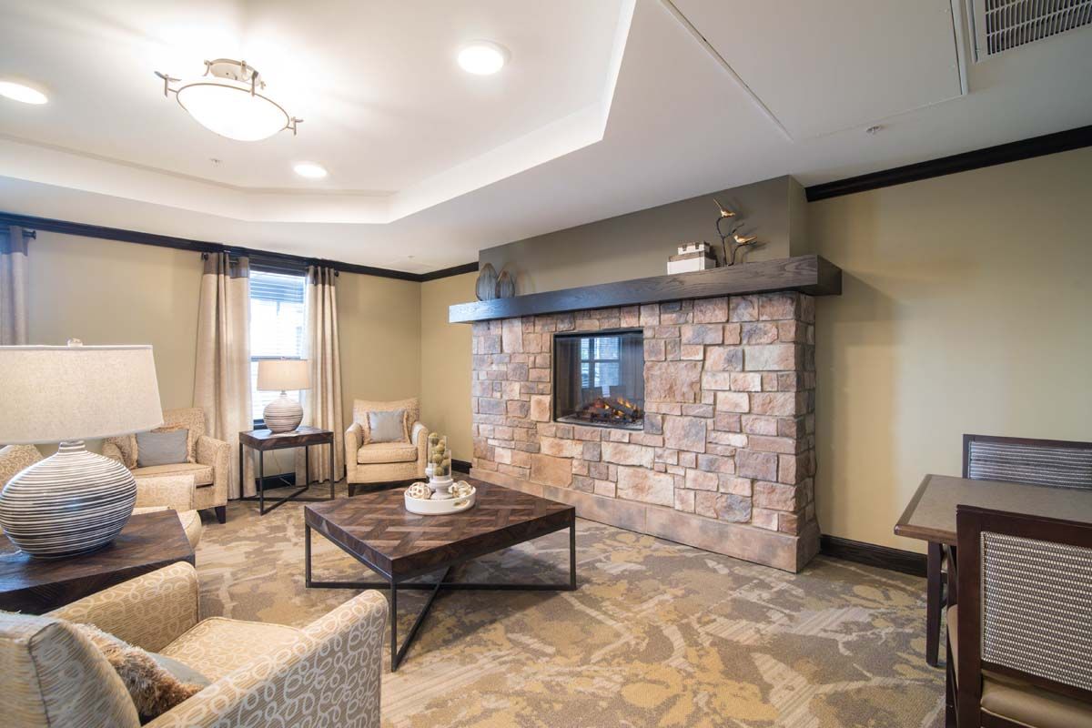 A modern and cozy living room featuring a stone fireplace and comfortable seating.