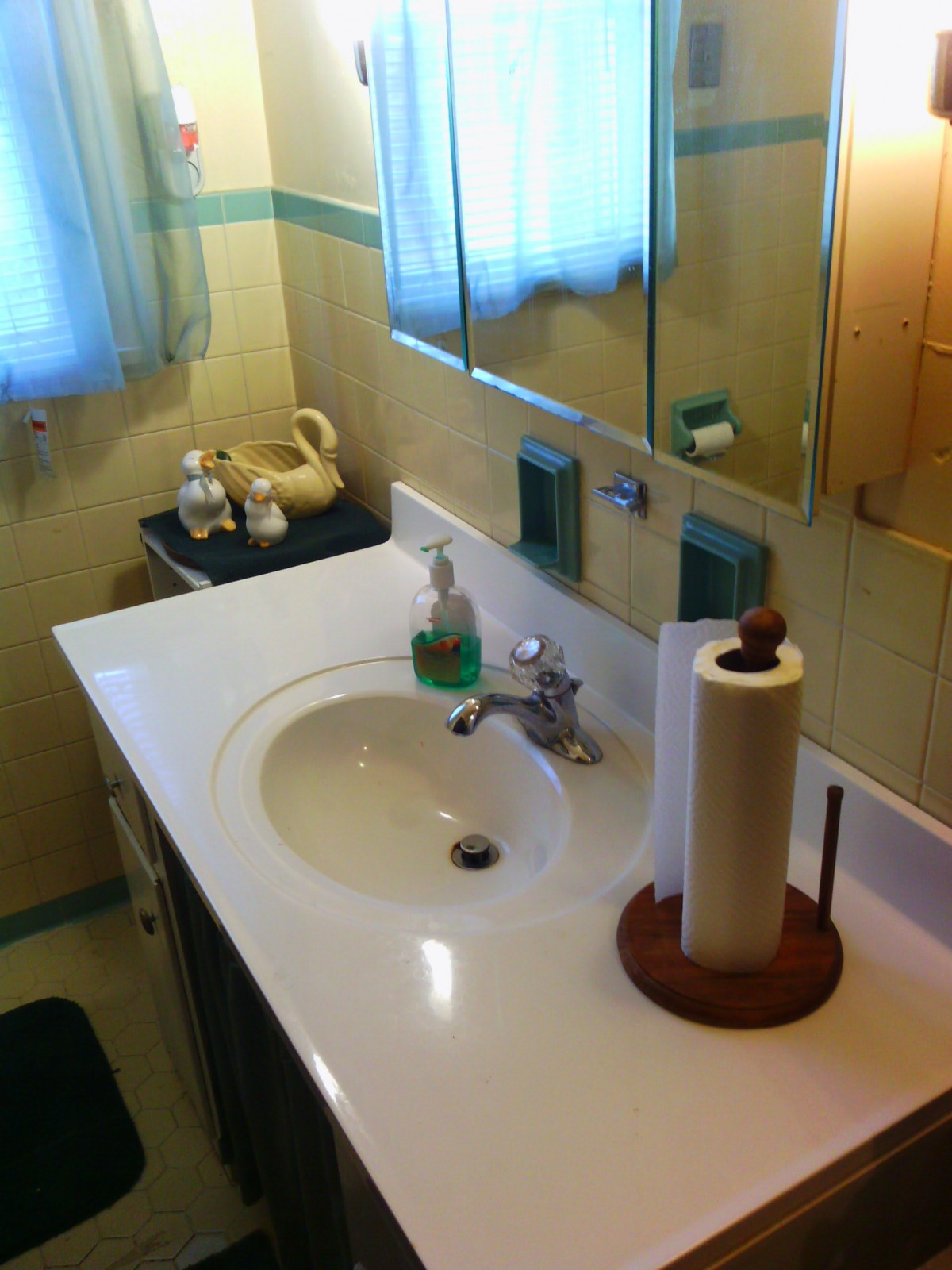 A cozy bathroom with a sink, mirror, and various toiletries arranged neatly.