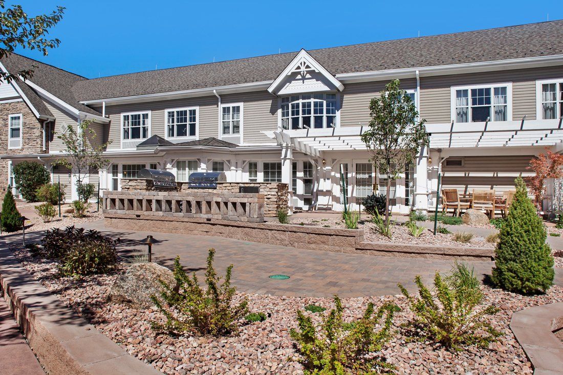 A large residential building with a landscaped garden in the foreground.