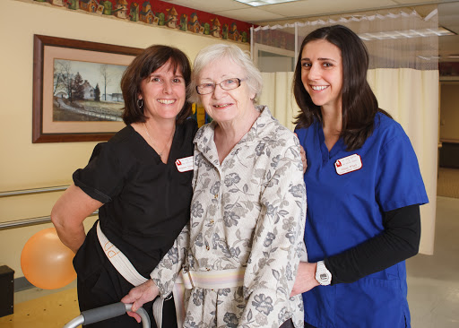 Caring moments in elderly support, showcasing dedicated nursing staff with a resident.