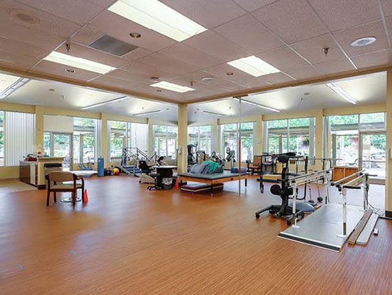 An empty physical therapy and rehabilitation center with various exercise equipment.