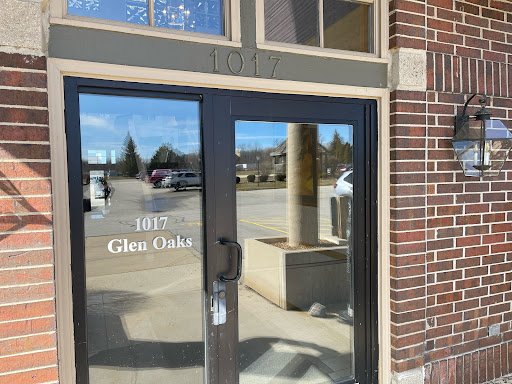 The entrance of a commercial building featuring a glass door and visible signage.
