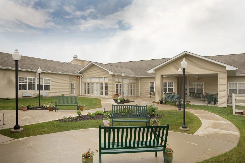 A courtyard with benches and landscaped pathways in front of a building.