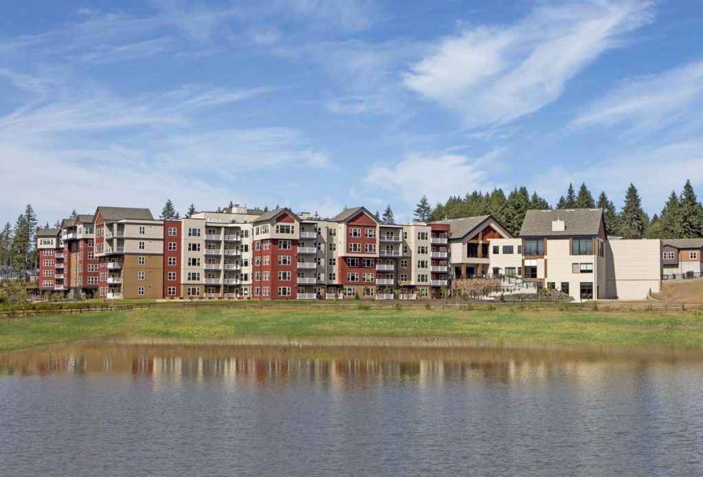 A scenic view of waterfront apartment buildings under a clear blue sky.