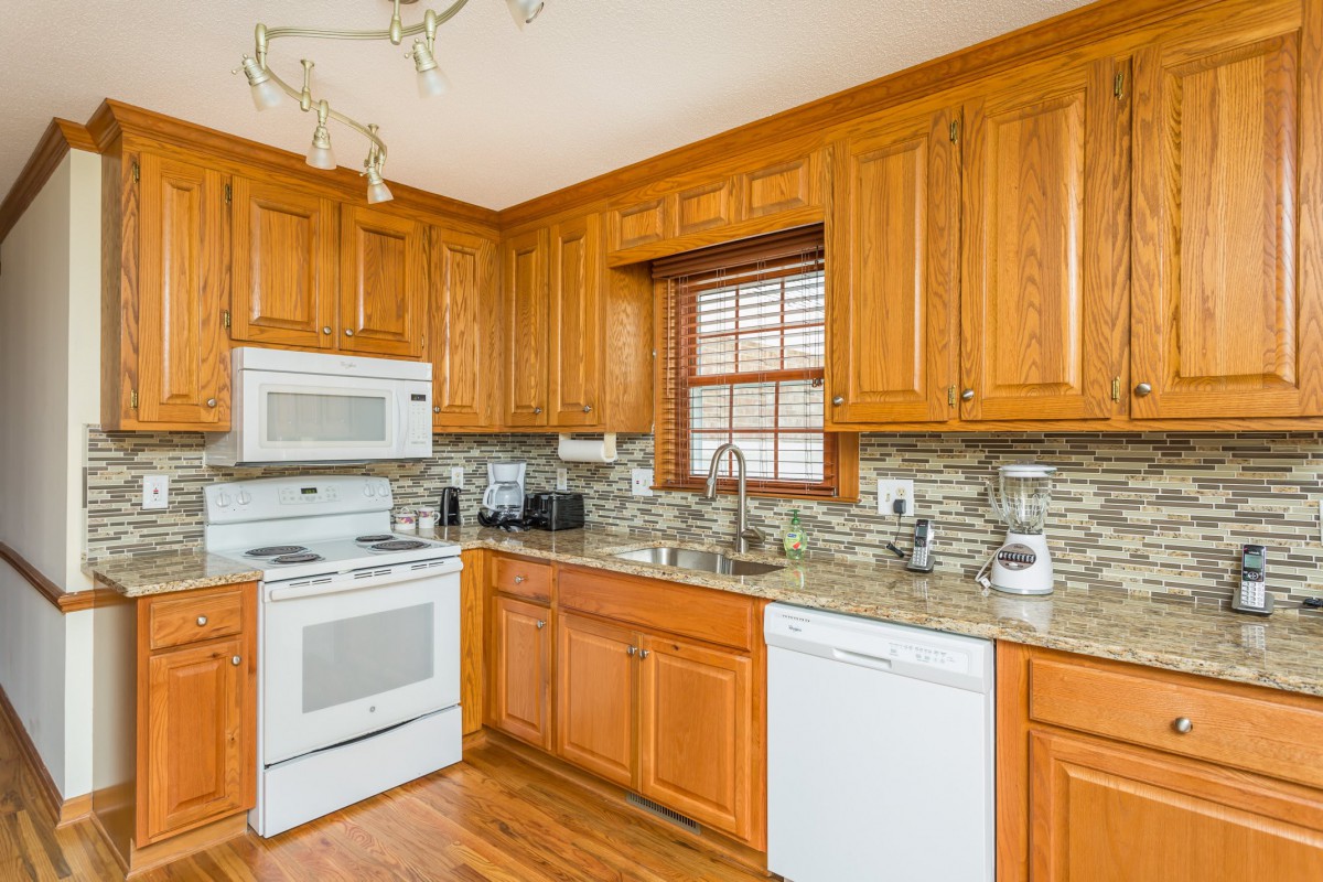 A modern kitchen with wooden cabinets and standard appliances.