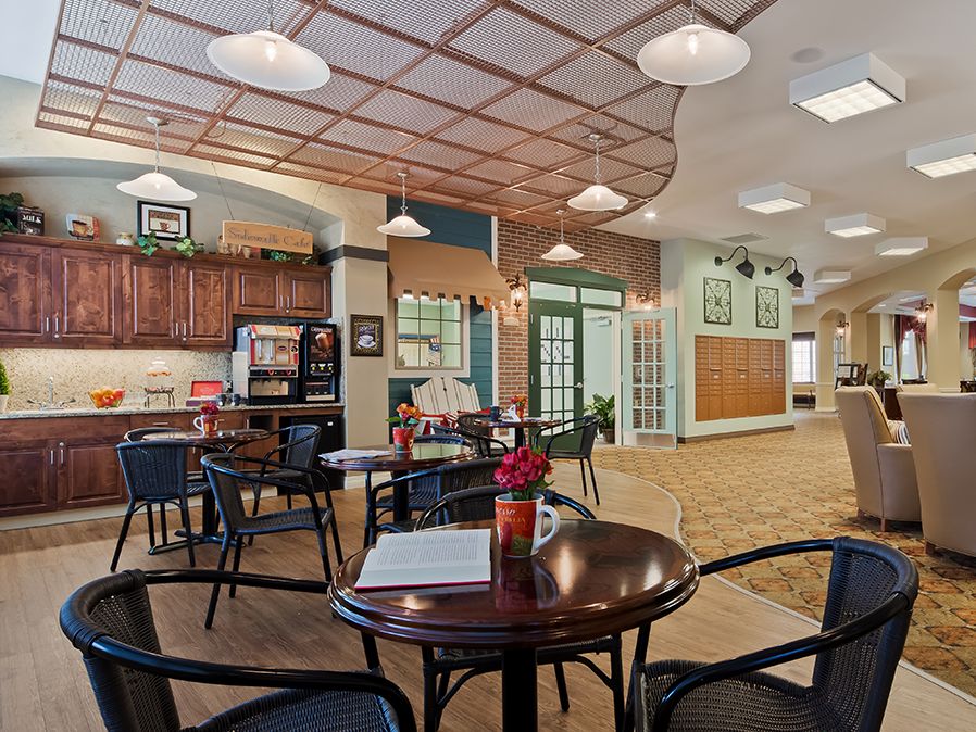 A cozy cafe interior with seating areas and warm lighting.