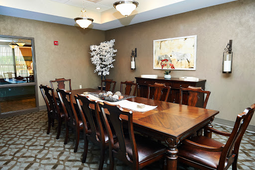 A well-furnished dining room featuring a large wooden table surrounded by chairs, complemented by decorative elements.