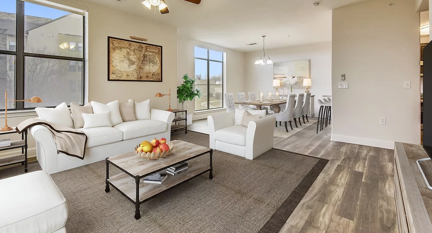 A spacious and elegantly designed modern living room with a connected dining area, featuring comfortable seating and tasteful decor.
