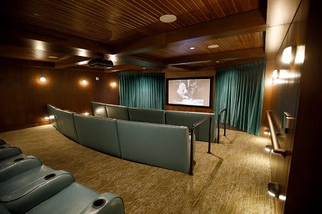 A cozy home theater with tiered seating and a large screen for optimal viewing.
