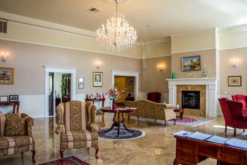 A luxurious lobby with elegant furnishings, a chandelier, and a fireplace.