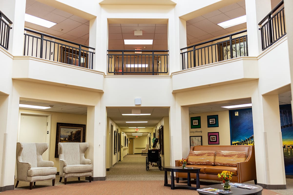 A spacious lobby with comfortable seating and a hallway leading to various rooms.