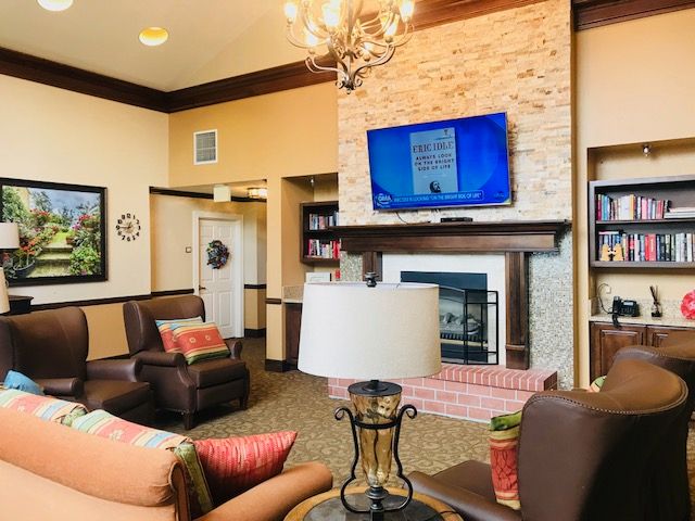 A cozy living room with comfortable seating, a fireplace, and a mounted television.