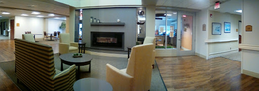 A cozy waiting area featuring modern furniture and a stylish fireplace.