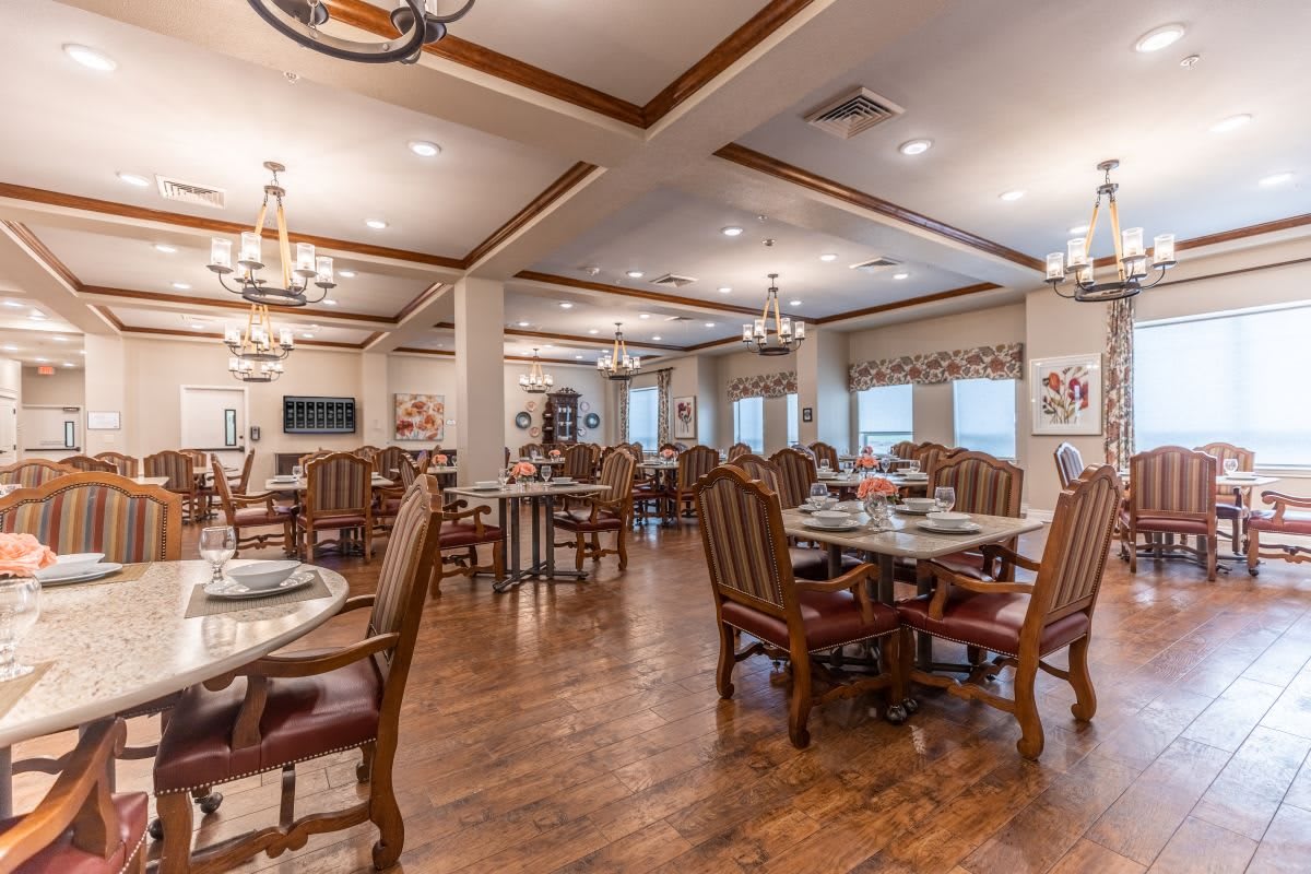 A spacious and elegantly designed dining room with wooden flooring and comfortable seating.