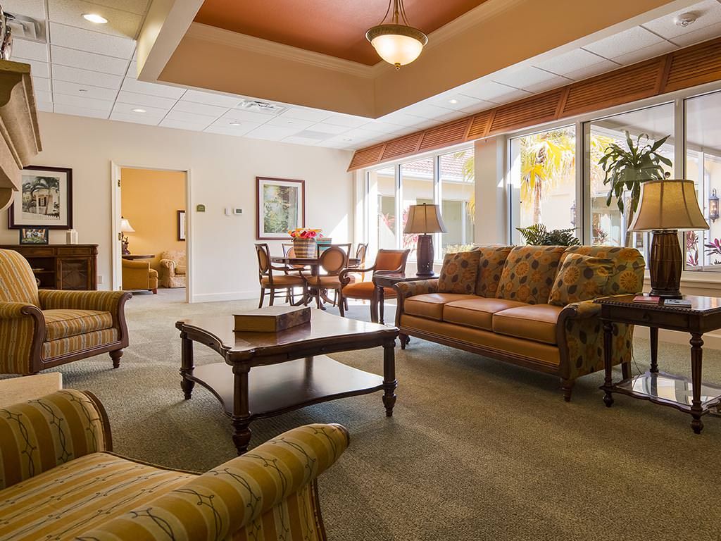 A cozy and well-furnished living room with sofas, chairs, and a coffee table, featuring large windows that let in natural light.
