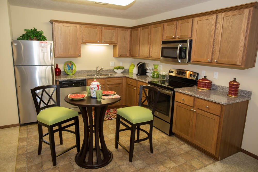 Modern kitchen with wooden cabinets and a compact dining set.
