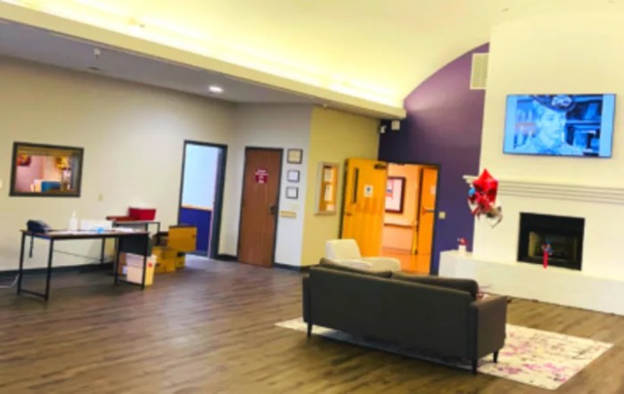 A well-lit office lobby with a couch and decorations on the wall.