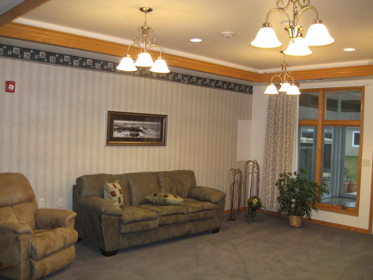 A warmly lit living room featuring a comfortable sofa, elegant lighting fixtures, and tasteful decor.
