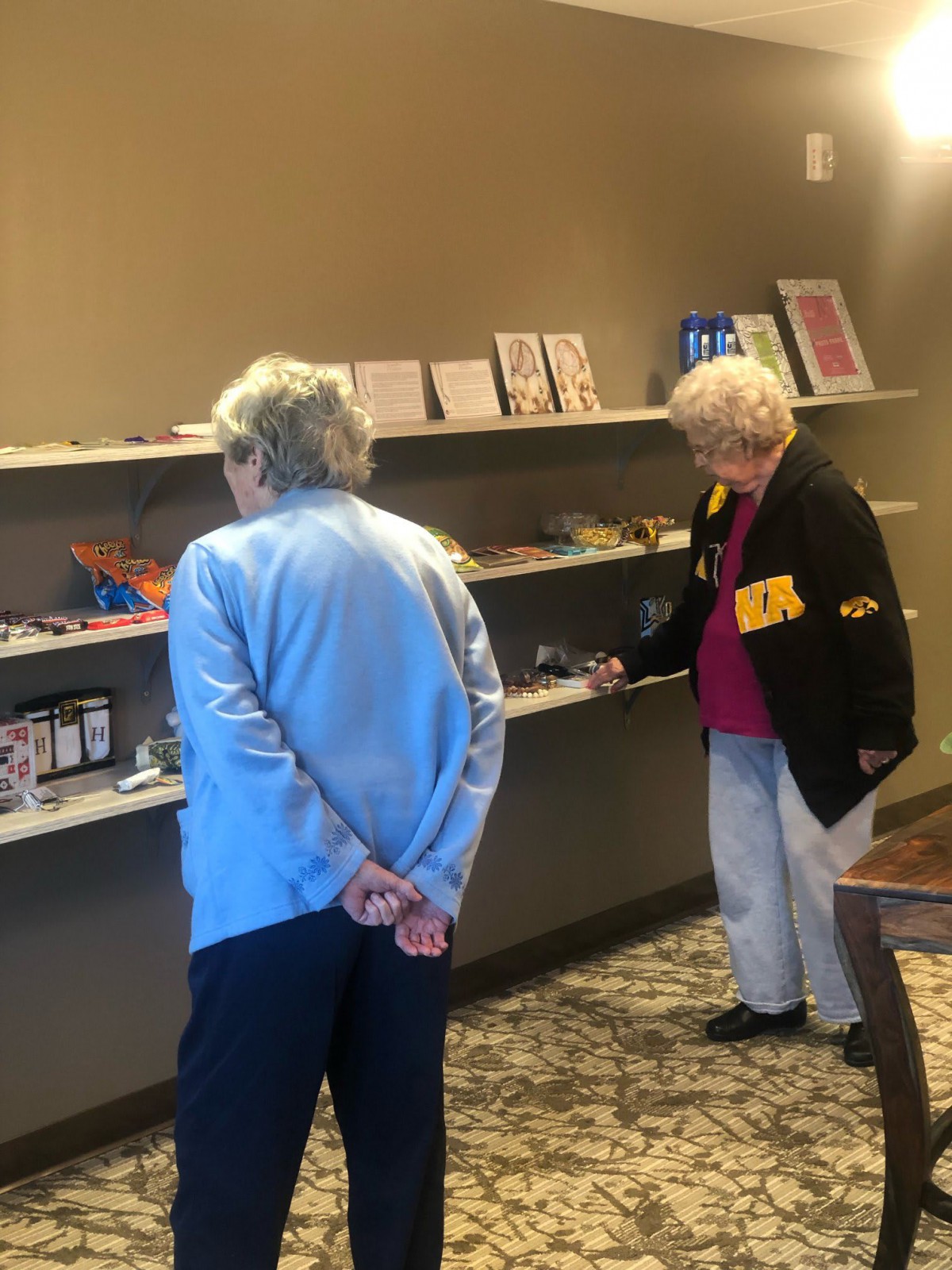 Two seniors viewing an art exhibit in a gallery.
