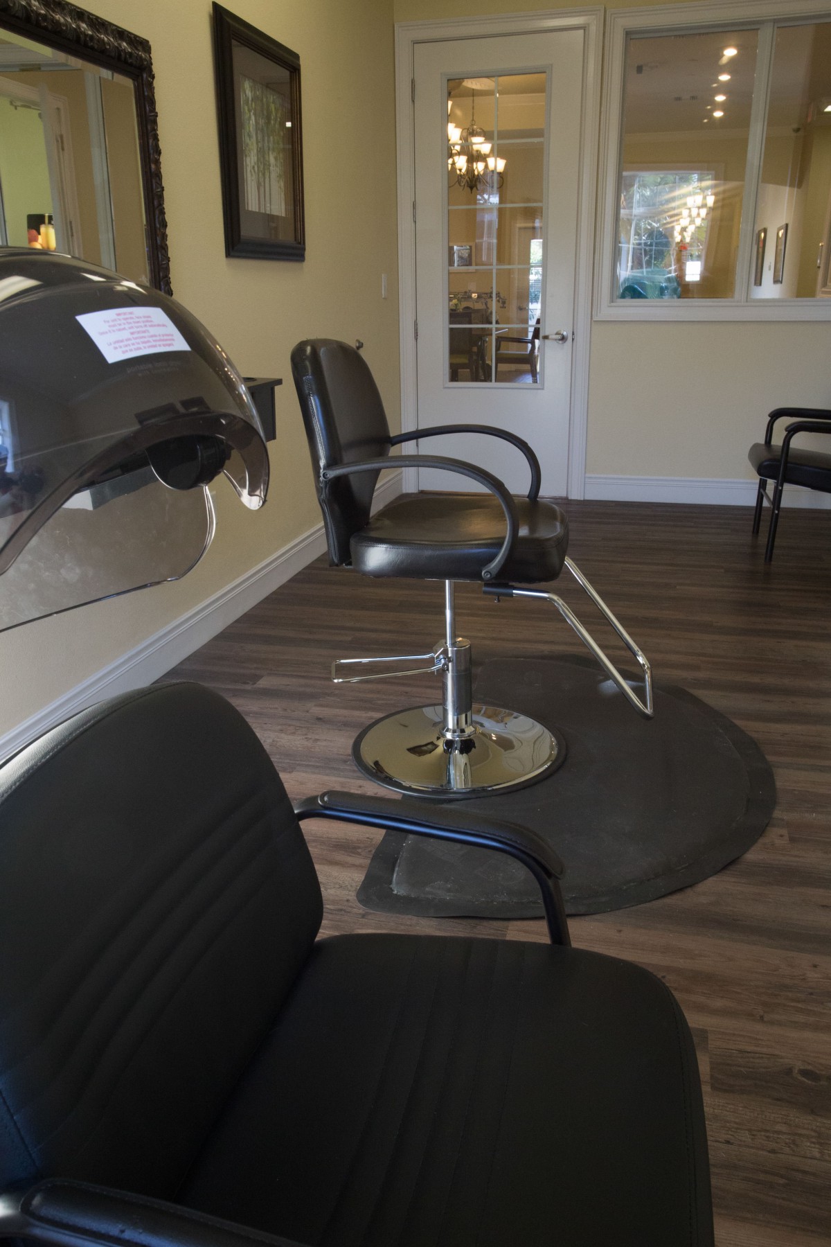 An empty hair salon with chairs and a hair dryer.