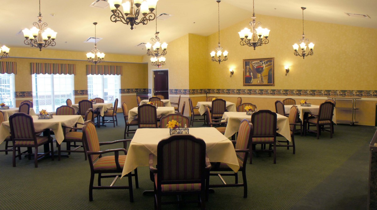 A well-decorated dining room with multiple tables and chandeliers.