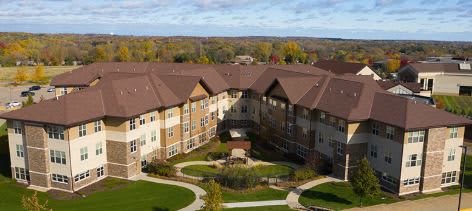 Aerial view of a large building surrounded by landscaped gardens.