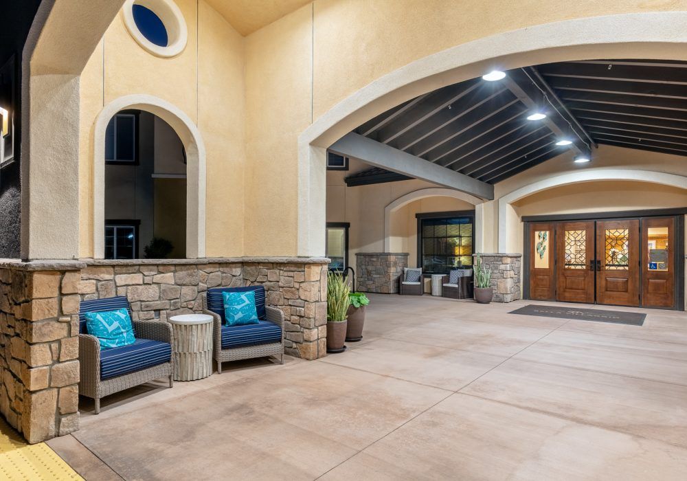 A well-lit entrance with outdoor seating and a covered walkway.