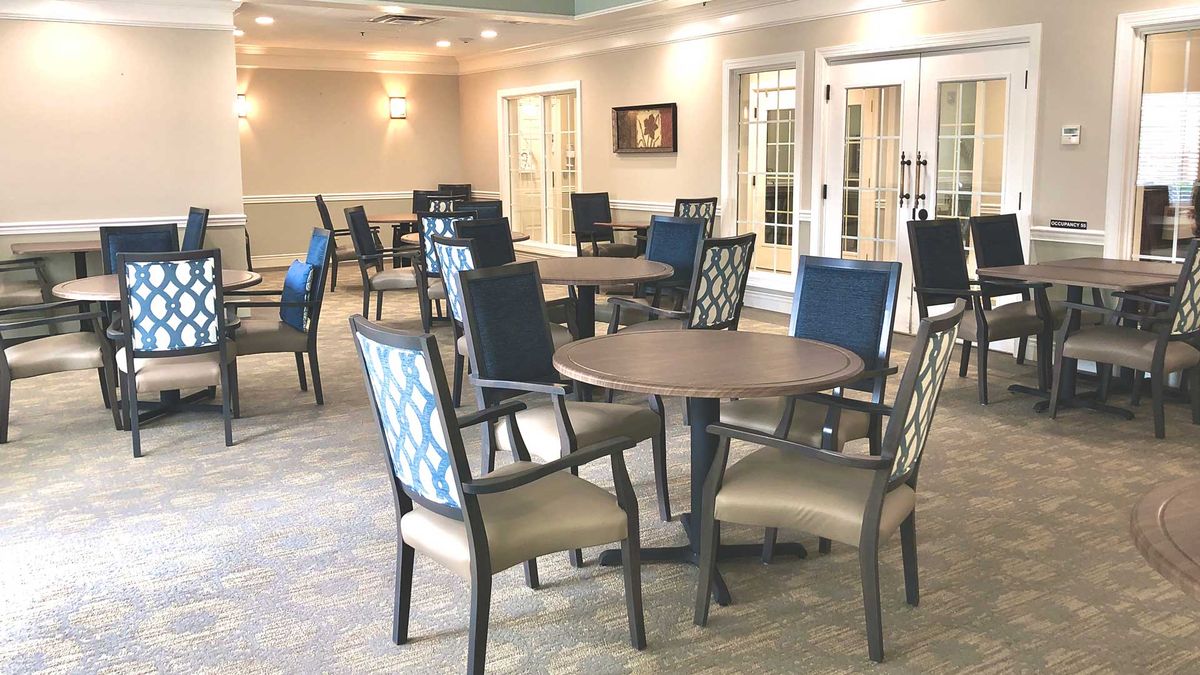 A well-lit dining area featuring multiple tables and chairs.