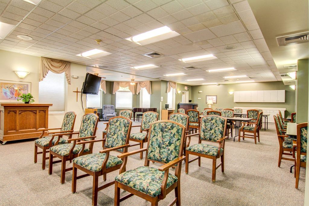 An empty conference room with patterned chairs arranged in rows.