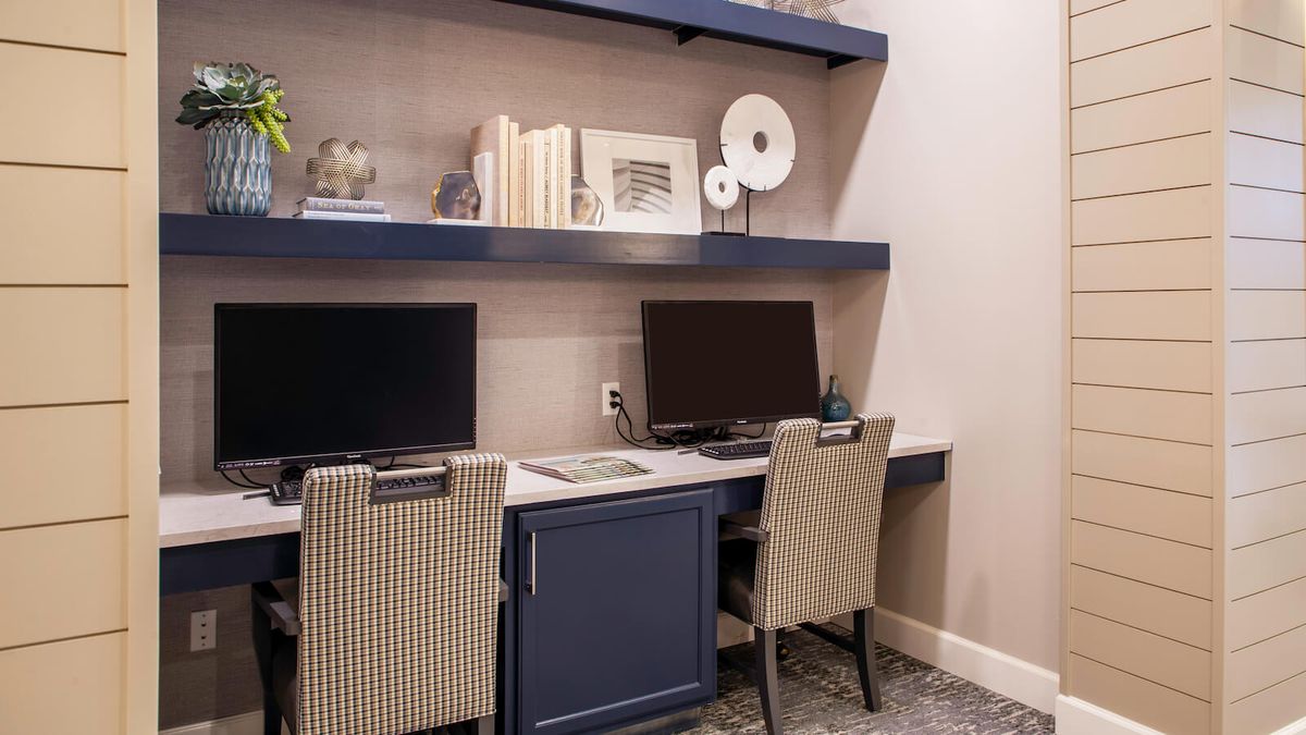 A cozy home office setup with dual desks and shelving for organization.