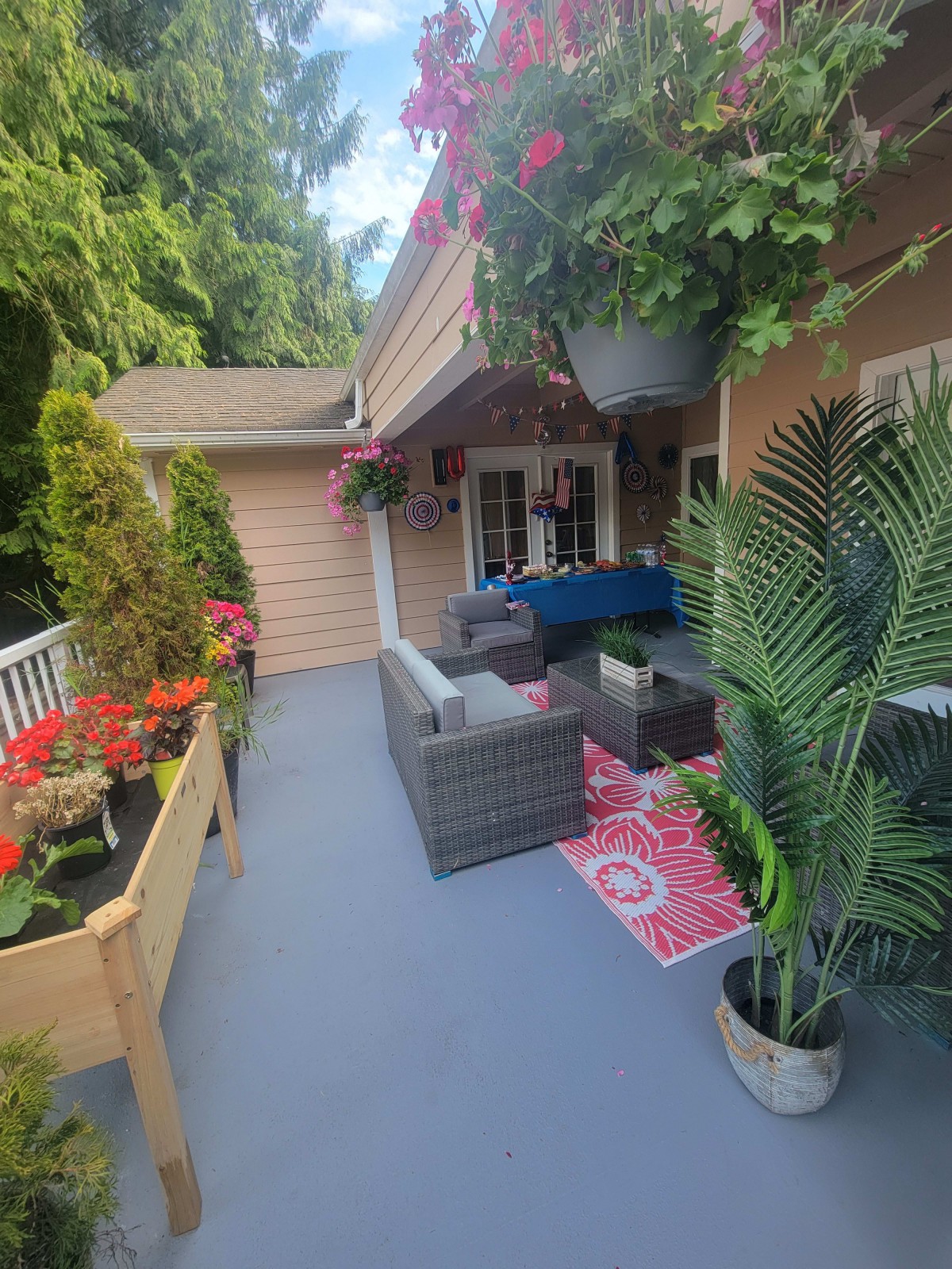 A cozy patio with outdoor furniture and vibrant plants.