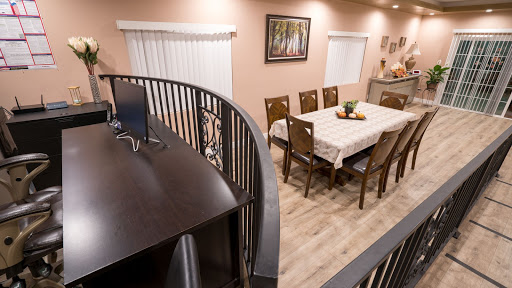 A cozy dining area featuring a wooden table set for meals, surrounded by elegant chairs and warm lighting.
