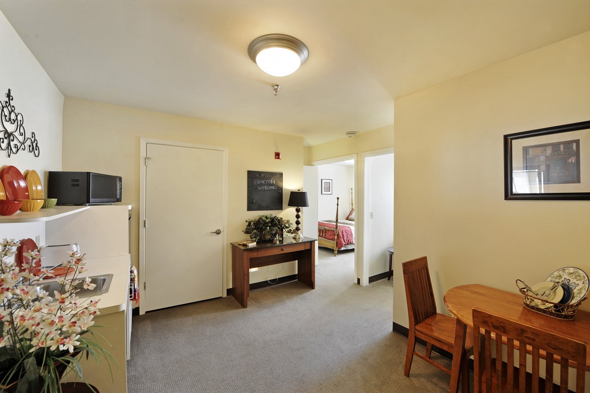A view of a cozy apartment interior with a dining area and visible bedroom.
