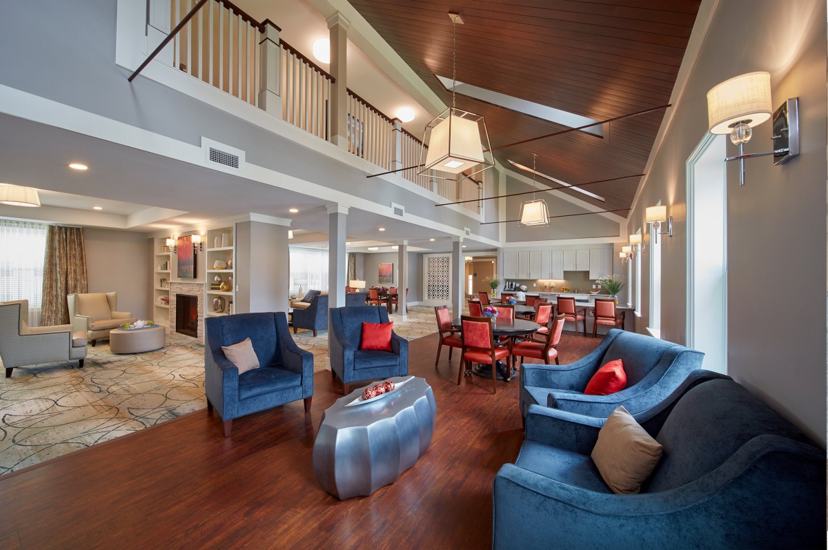 A modern open-concept living area featuring stylish blue chairs and hardwood flooring.