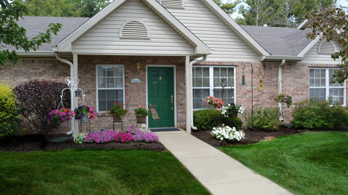 A charming house with a landscaped garden and green front door.