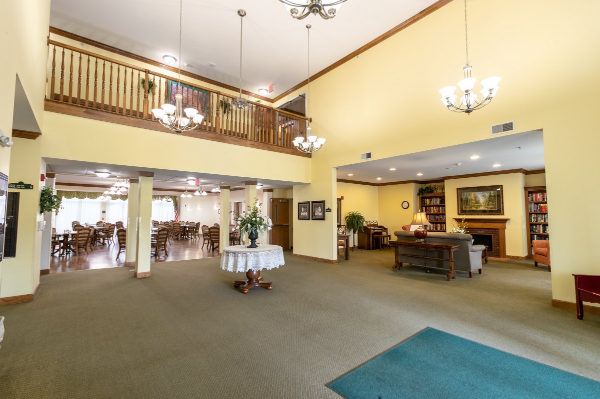 A spacious hotel lobby with elegant chandeliers and a reception desk.