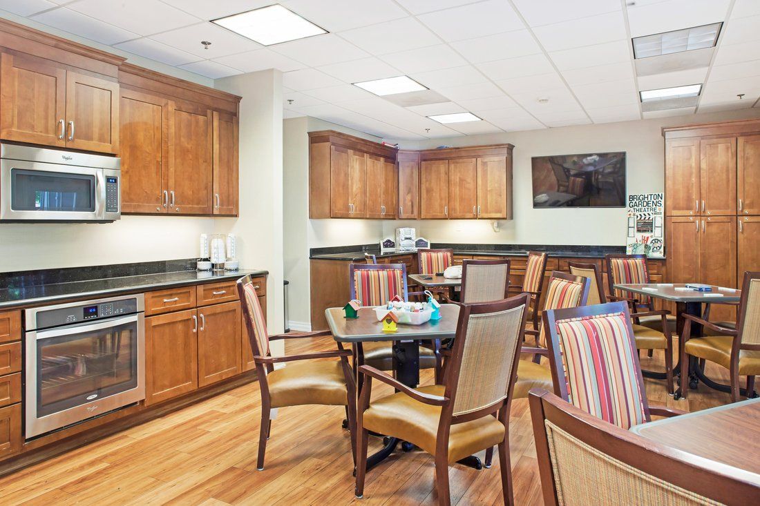 A modern kitchen and dining area with wooden cabinets and striped upholstered chairs.