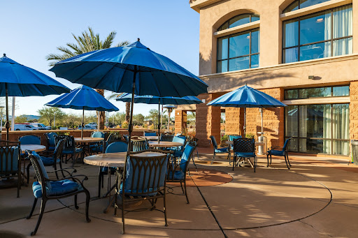 A tranquil outdoor patio area featuring blue umbrellas and comfortable seating.