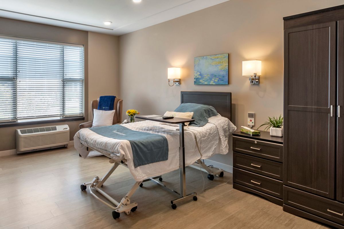 A well-furnished hospital room with a bed and medical equipment.