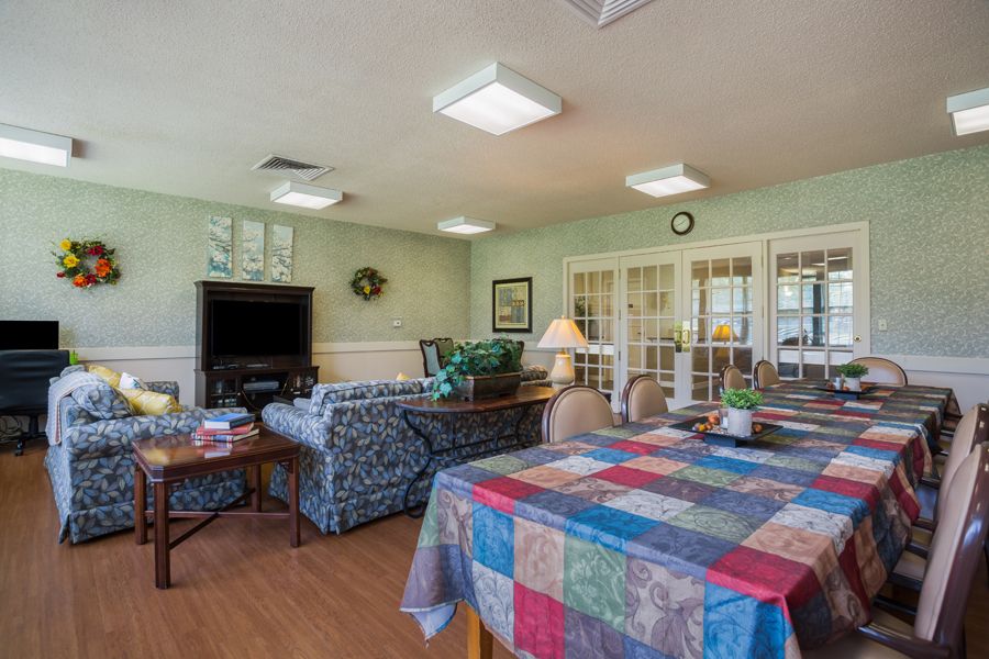 A cozy living room with colorful tablecloths, a sofa, and a television.