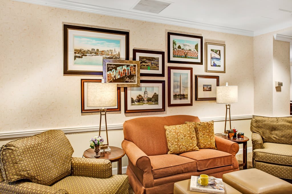 A cozy living room with framed artwork on the wall and comfortable seating.