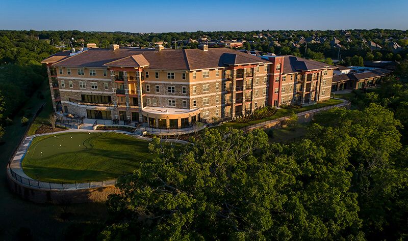 Aerial view of a residential apartment building surrounded by lush greenery.