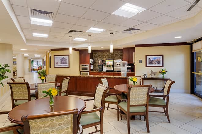 A cozy indoor cafe seating area with tables and chairs, decorated with flowers.