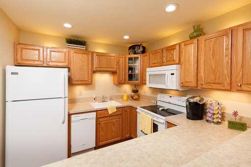 A cozy and modern kitchen featuring wooden cabinets and essential appliances.