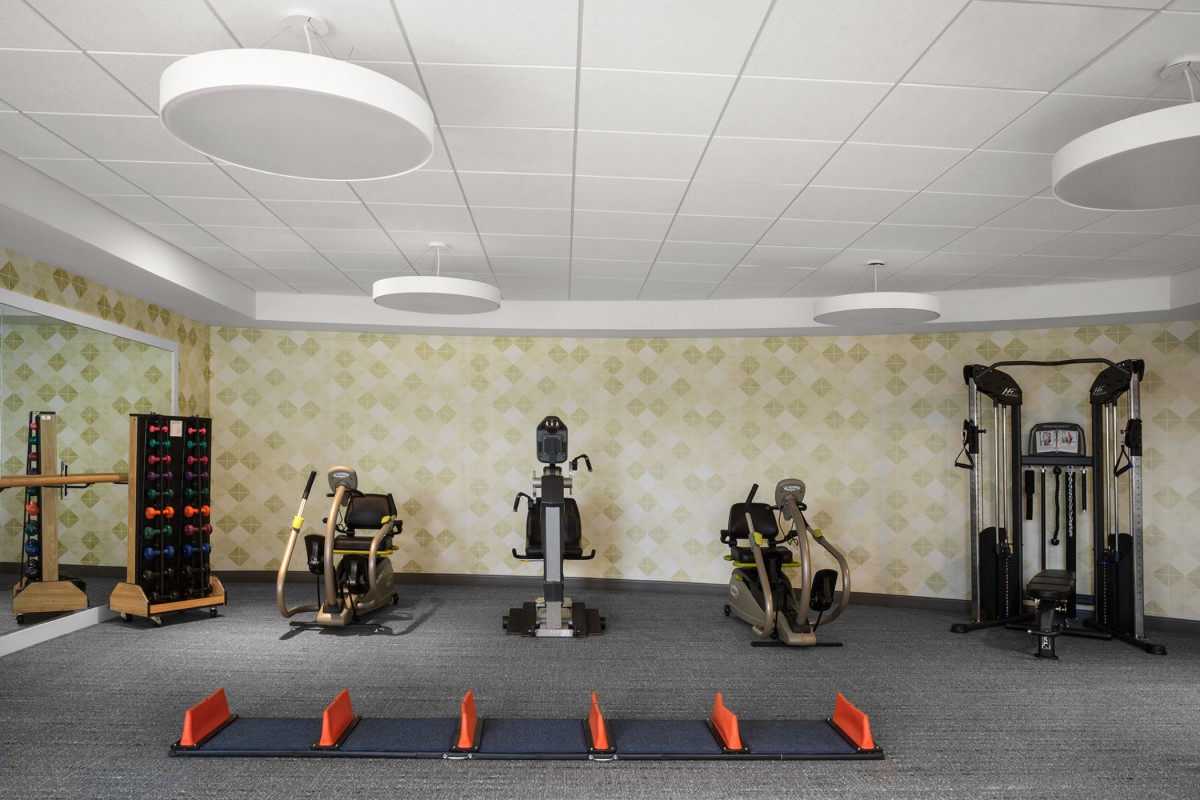 A well-equipped gym with various fitness machines and a workout space.
