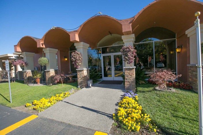 A welcoming entrance with arched roof and vibrant landscaping.