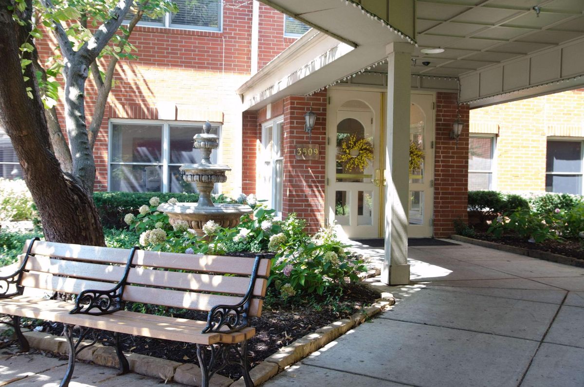 A welcoming entrance with a bench and garden area featuring a fountain.