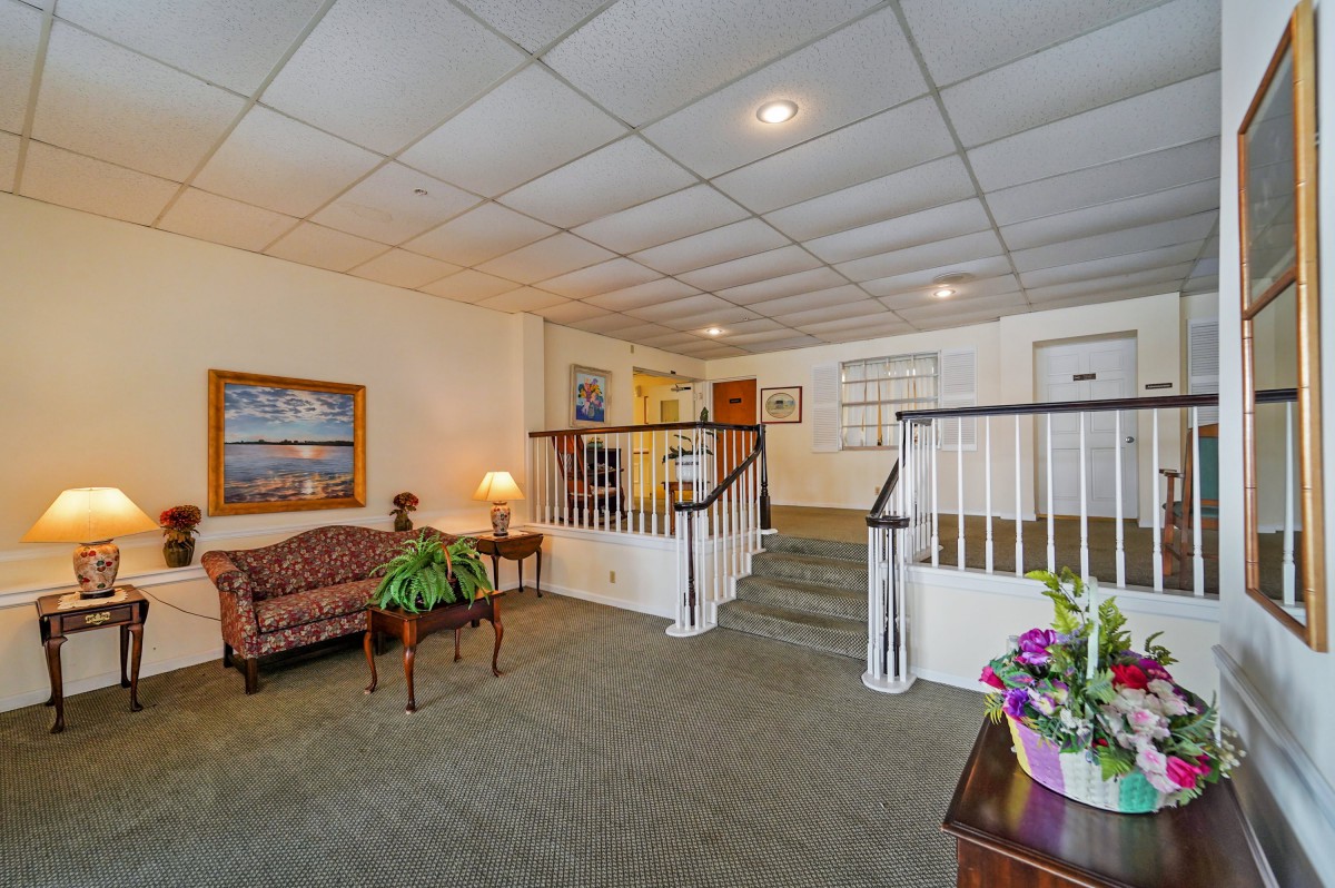 A cozy interior lobby featuring a staircase, seating area, and decorative elements.