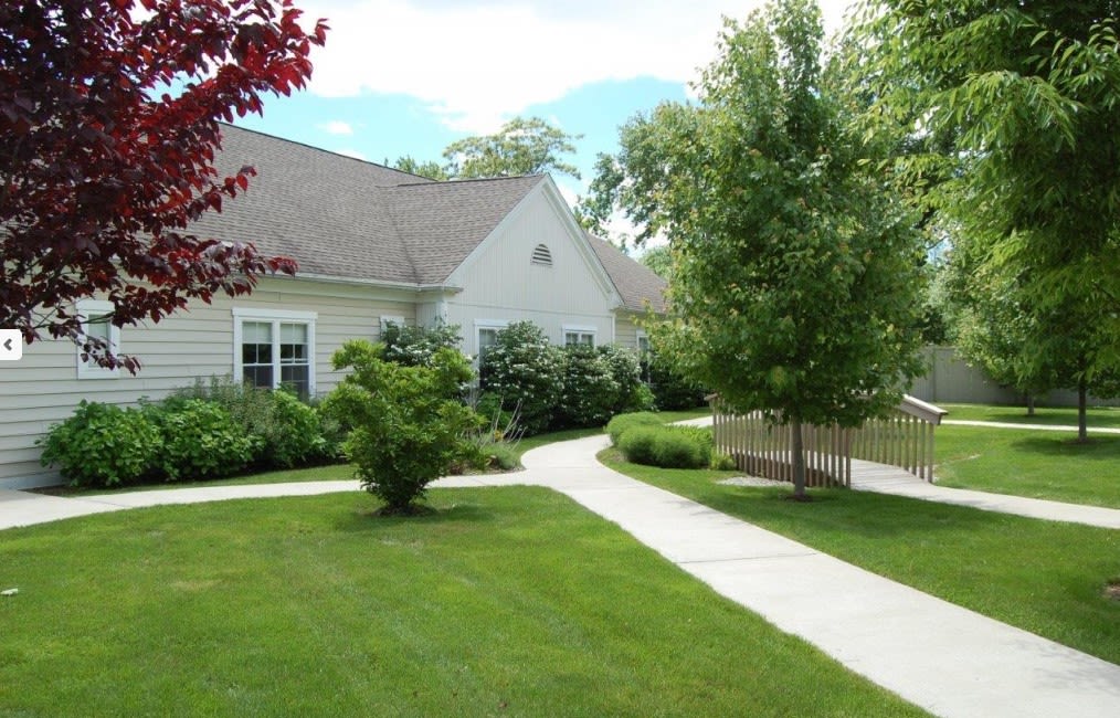 A suburban house with a well-maintained lawn and a winding sidewalk.
