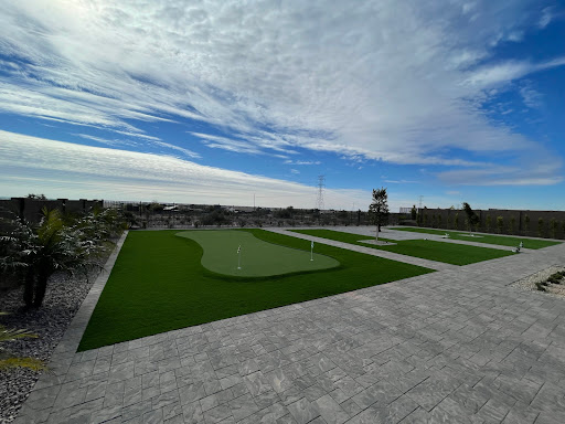 A serene outdoor recreation area featuring a well-maintained golf green under a partly cloudy sky.